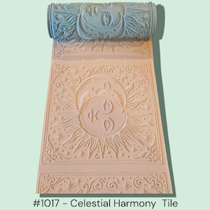 May include: A light blue patterned roller and a beige tile with a celestial design. The tile features a sun and moon motif with radiating lines and stars. The roller has a similar design. The text on the image reads "#1017 - Celestial Harmony Tile."