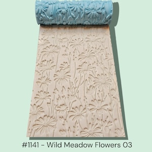 May include: A light blue floral pattern roller with a matching embossed design on the surface. The roller is used to create a textured pattern of wild meadow flowers on a light beige surface. The text "#1141 - Wild Meadow Flowers O3" is at the bottom.