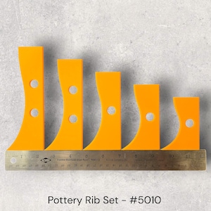 May include: A set of five bright orange pottery ribs with curved edges and circular holes. A flexible stainless steel ruler is placed below the ribs, with the text "Pottery Rib Set - #5010" at the bottom.
