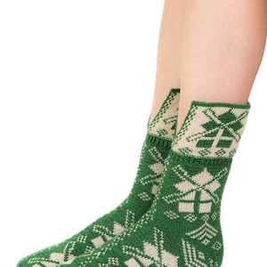 Puede incluir: Calcetines de punto verdes y crema con un patrón geométrico. Los calcetines presentan un diseño repetido de copos de nieve y otras formas. El puño del calcetín es de color crema y el resto del calcetín es verde.