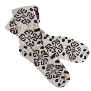 Puede incluir: Un par de calcetines gris claro con un estampado floral negro. Los calcetines tienen un puño acanalado y un diseño repetido de puntos negros y flores estilizadas. Los calcetines están hechos de un material suave y tejido.