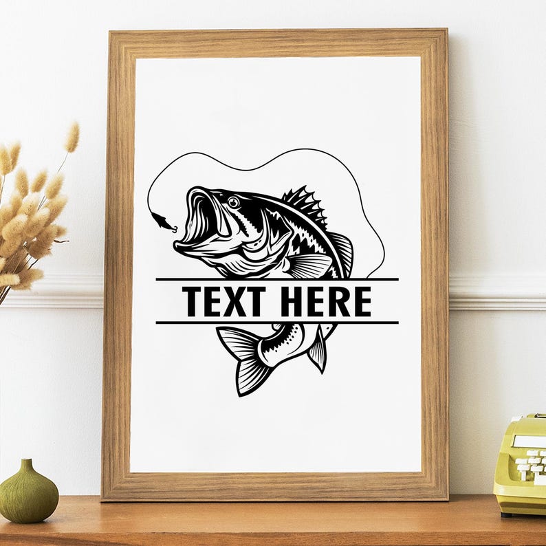May include: A framed black and white illustration of a largemouth bass with an open mouth, hook, and line. The text "TEXT HERE" is centered below the fish. The artwork is in a wooden frame.