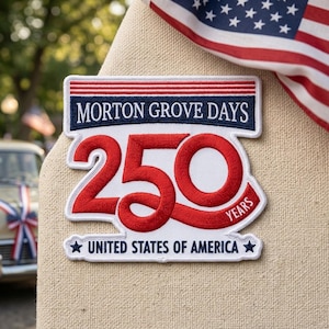 May include: Embroidered patch with the text "MORTON GROVE DAYS" above a large red "250" and "YEARS". The patch also includes "UNITED STATES OF AMERICA" and a star. An American flag is in the background.
