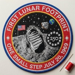 May include: Embroidered patch commemorating the first lunar footprint. The circular design features a footprint, American flag, spacecraft, and the Earth against a starry background. Text includes "FIRST LUNAR FOOTPRINT" and "ONE SMALL STEP JULY 20, 1969".