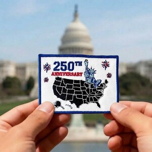 May include: A rectangular patch with a white background and a blue border. The patch features a black outline of the United States with the Statue of Liberty in blue. The text "250th Anniversary" is printed on the patch in blue and red.