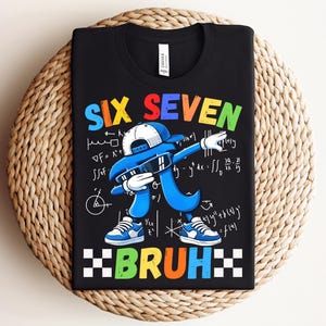 May include: Black t-shirt with a colorful graphic featuring the words "SIX SEVEN BRUH". The design includes a blue figure dabbing, wearing a cap and sunglasses, with mathematical symbols in the background.