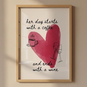 Könnte beinhalten: Gerahmter Kunstdruck mit hellem Holzrahmen. Das Kunstwerk zeigt ein großes rosa Herz mit dem Text "her day starts with a coffee and ends with a wine." Enthält Kaffeetassen- und Weinglasillustrationen.