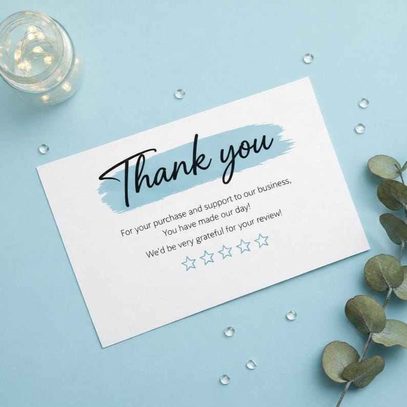 May include: A white rectangular thank you card featuring a light blue brushstroke background behind the black text Thank you. Below, the text reads For your purchase and support to our business, You have made our day! We'd be very grateful for your review! with five light blue star outlines.
