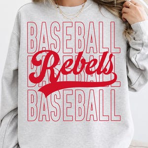 May include: A light gray sweatshirt with the words "BASEBALL Rebels BASEBALL" in red. The word "Rebels" is in a cursive font. The sweatshirt is long-sleeved and has a crew neck.