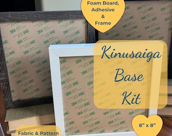May include: A Kinusaiga Base Kit featuring a white frame and a dark wood frame, each containing foam board with 3M adhesive backing. The kit includes the foam board, adhesive, and frames, measuring 8 inches by 8 inches. Fabric and pattern are not included.