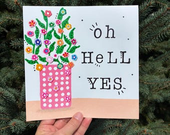 May include: A square greeting card featuring a pink vase with white polka dots filled with colorful floral embellishments. The text "oh HeLL YES" is printed in black ink on the right side of the white card, which sits on a light peach base.