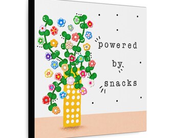 May include: A square canvas wall art piece featuring a yellow vase with white polka dots containing green stems with colorful small flowers. The text "powered by snacks" is printed in black typewriter font on the right side against a white background.