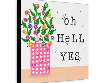May include: A square wall art piece featuring a pink vase with white polka dots containing green stems and colorful small flowers. To the right of the vase, the text "oh HeLL YES" is printed in black, stylized lettering against a white background.