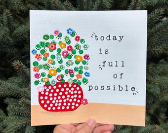 May include: A square art print on a light background featuring a red vase with white polka dots filled with colorful small flower embellishments. The text "today is full of possible" is printed in black typewriter-style font on the right side.