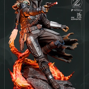 Pu&ograve; includere: Statua dettagliata di The Mandalorian, vestito con un'armatura scura, che punta un blaster. Una piccola figura aliena verde &egrave; seduta sulla sua spalla. La base presenta fiamme arancioni e gialle e terreno roccioso. Il logo Zenith &egrave; visibile.
