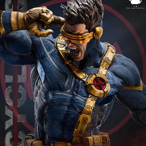 Puede incluir: Estatua detallada del personaje Cíclope de los X-Men en una pose dinámica. La figura está vestida con un traje azul y dorado, con una visera dorada y detalles intrincados. La estatua tiene una expresión severa y está pre-soportada.
