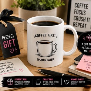 Op de afbeelding: Een witte keramische koffiemok met de tekst "COFFEE FIRST EMAILS LATER" en een illustratie van een koffiekopje. De mok is gevuld met koffie en staat op een houten oppervlak met een geschenkdoos, notitieblok en pen.