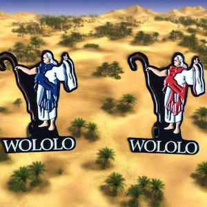 Könnte beinhalten: Zwei dekorative Figuren einer Figur mit Stab vor einer Wüstenlandschaft. Eine Figur trägt blaue und weiße Roben, die andere rote und weiße. Das Wort "WOLOLO" befindet sich am Fuß jeder Figur.
