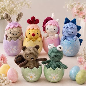 Peut inclure: Six figurines d'animaux en crochet, incluant un lapin, un poussin, une licorne, un dinosaure, un ours et une grenouille, nichées dans des coquilles d'œuf en céramique peintes avec un motif de marguerite blanche et une finition mouchetée.
