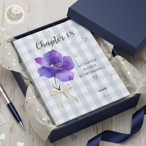 Diário personalizado com a flor de nascimento, capa dura azul acinzentada, caderno com 18 espaços para nome.