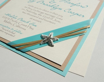 May include: A wedding invitation with a blue and tan layered design. The invitation features a silver starfish and the text "banford & Brooklyn Cooper" and "Malibu Beach Inn".