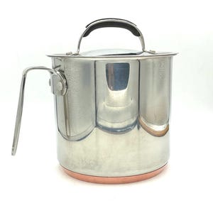 May include: A stainless steel saucepan with a copper bottom and a black handle. The saucepan has a lid.
