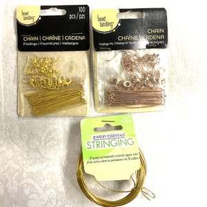 May include: An assortment of jewelry-making supplies, including gold-colored chain findings, copper-colored chain findings, and a spool of gold-colored stringing wire. The packages have the text "CHAIN" and "STRINGING".