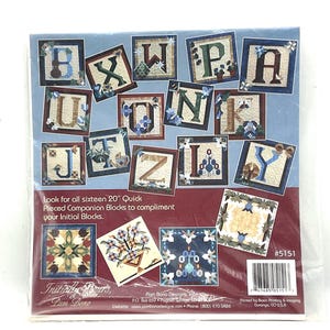 May include: A package of sixteen 20-inch quick pieced companion blocks to complement initial blocks. The blocks feature letters of the alphabet with floral accents. The package has a blue background and a red border.