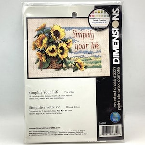 May include: Cross stitch pattern featuring a bouquet of sunflowers in a pot with the text "Simplify your life". The pattern is 7 inches by 5 inches and includes 14 count natural cotton Aida, thread, needle, and easy instructions.