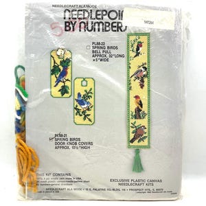 May include: A vintage Needlecraft kit featuring a "Spring Birds" design. The kit includes materials for a bell pull, approximately 32 inches long and 5 inches wide, and door knob covers, approximately 10.5 inches high. The package shows finished needlepoint examples.