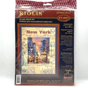 May include: A cross-stitch kit featuring a New York City scene with skyscrapers, streetlights, and the Statue of Liberty. The kit includes Zweigart Aida fabric, a color chart, a needle, and Anchor stranded cotton. Finished size is 11.75" x 15.75".