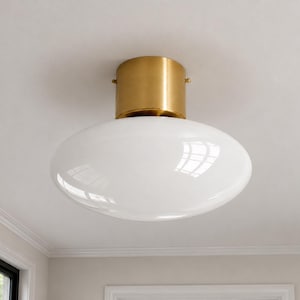 Plafoniera in ottone stile Mid-Century Modern con globo in vetro bianco, lampada a sospensione minimalista Art Déco, unica per soggiorno e ingresso.
