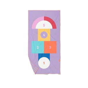 May include: A rectangular, lavender-colored beach towel with a colorful hopscotch design. The design includes a white circle, two rectangles, a square, and a half-circle, each with a different color and number. The towel has a pink border.
