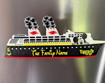 May include: A cruise ship magnet featuring a black hull with a yellow anchor, white upper decks, and two smokestacks with grey smoke clouds. The text reads The Family Name and Fantasy in yellow. A Mickey Mouse character peeks over the deck.