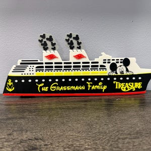 May include: A decorative cruise ship sign featuring a black hull with a red base, white upper decks, and two smokestacks with black Mickey Mouse head patterns. The text reads The Grassmann Family and Treasure, with a yellow anchor and Mickey icon.