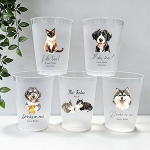 May include: Five frosted plastic cups featuring custom pet illustrations and text. The cups display various cats and dogs, with phrases like I do too!, Drinks on me!, and The Fretas, along with names and dates printed in black ink on the front surface.