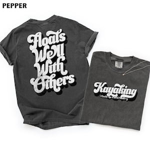 Peut inclure: Deux t-shirts gris anthracite. L'un porte l'inscription blanche "Floats Well With Others", l'autre "Kayaking I Could Use a Good Paddling". Les t-shirts sont en matière souple.