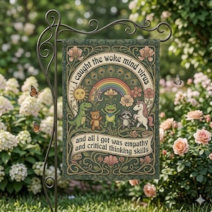 May include: A garden flag with the text "I caught the woke mind virus" and "and all I got was empathy and critical thinking skills." The flag features a rainbow, sun, and cartoon animals in a whimsical design.