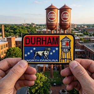 May include: A patch with the word "DURHAM" in red letters, a blue section with a white bull and stars, and the words "NORTH CAROLINA". Two brown water towers with "Lucky Strike" logos are in the background.