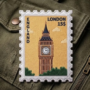 May include: A rectangular embroidered patch shaped like a postage stamp featuring the Elizabeth Tower in London. The design includes the text ENGLAND, LONDON, and 15$. The tower is brown with a blue roof, set against a yellow background.