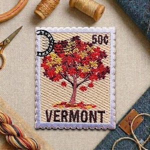 May include: Embroidered Vermont stamp featuring a tree with red and yellow leaves, with the text "VERMONT" at the bottom. The stamp has a scalloped border and the text "50¢".