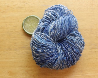 May include: A ball of blue and white yarn with a white background.
