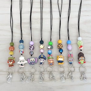 May include: A collection of beaded lanyards with cartoon character charms. Each lanyard features a black cord, decorative beads in various colors, and a character charm. The lanyards have a metal clasp and a clear plastic card holder.