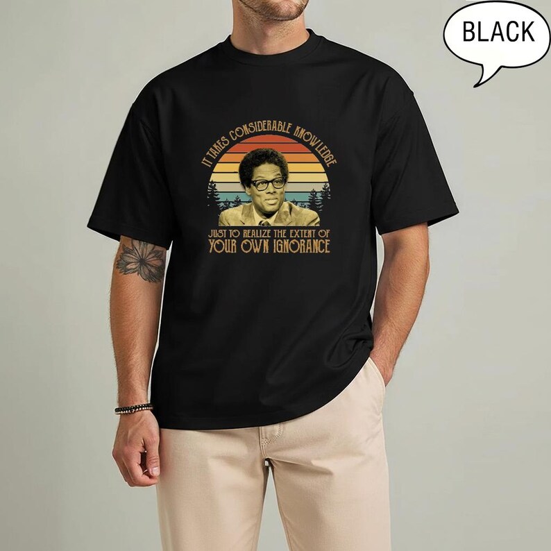 May include: Black t-shirt featuring a vintage-style graphic of a man wearing glasses, set against a sunset backdrop with trees. The text reads, "It takes considerable knowledge just to realize the extent of your own ignorance."