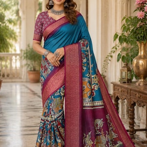 May include: A teal blue saree featuring a wide magenta border with intricate gold woven patterns. The fabric displays detailed multi-colored traditional figurative illustrations along the lower section and a matching magenta blouse with a white geometric print.