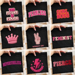 Op de afbeelding: Negen zwarte t-shirts met diverse geborduurde ontwerpen. De ontwerpen bevatten teksten als "The Future is Female", "Fearless", "Girl Boss", "Feminist" en "Fierce". Andere ontwerpen tonen een roze kroon, een vredesteken en een bliksemschicht met de woorden "Empowerment" en "Women's Day".