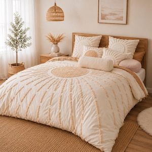 May include: A bedroom scene featuring a bed with a cream-colored comforter and pillows. The comforter has a sunburst design with textured accents. The room includes a wooden headboard, a woven pendant light, and a jute rug, creating a warm, inviting atmosphere.