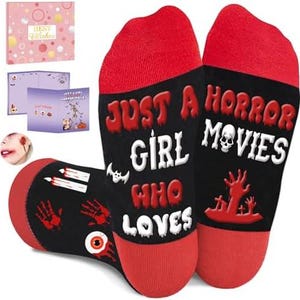 May include: A pair of black and red socks featuring the text "JUST A GIRL WHO LOVES HORROR MOVIES" in white and red lettering. The design includes graphics of a skull, a hand emerging from a grave, a bat, candles, and a human eyeball.