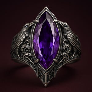 May include: A silver ring featuring a large, marquise-cut purple gemstone. Two detailed raven figures flank the gem, with intricate scrollwork and a pointed base. The ring's design is gothic and ornate.