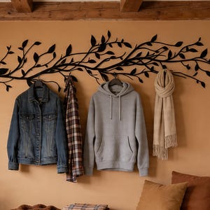 May include: A cozy interior scene with a wooden bench, pillows, and a plant. A denim jacket, gray hoodie, and scarf hang on the wall. Boots and shoes are placed under the bench. A decorative branch with leaves is mounted on the wall.